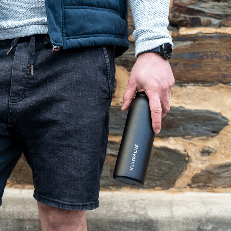 A man holding a black bottle